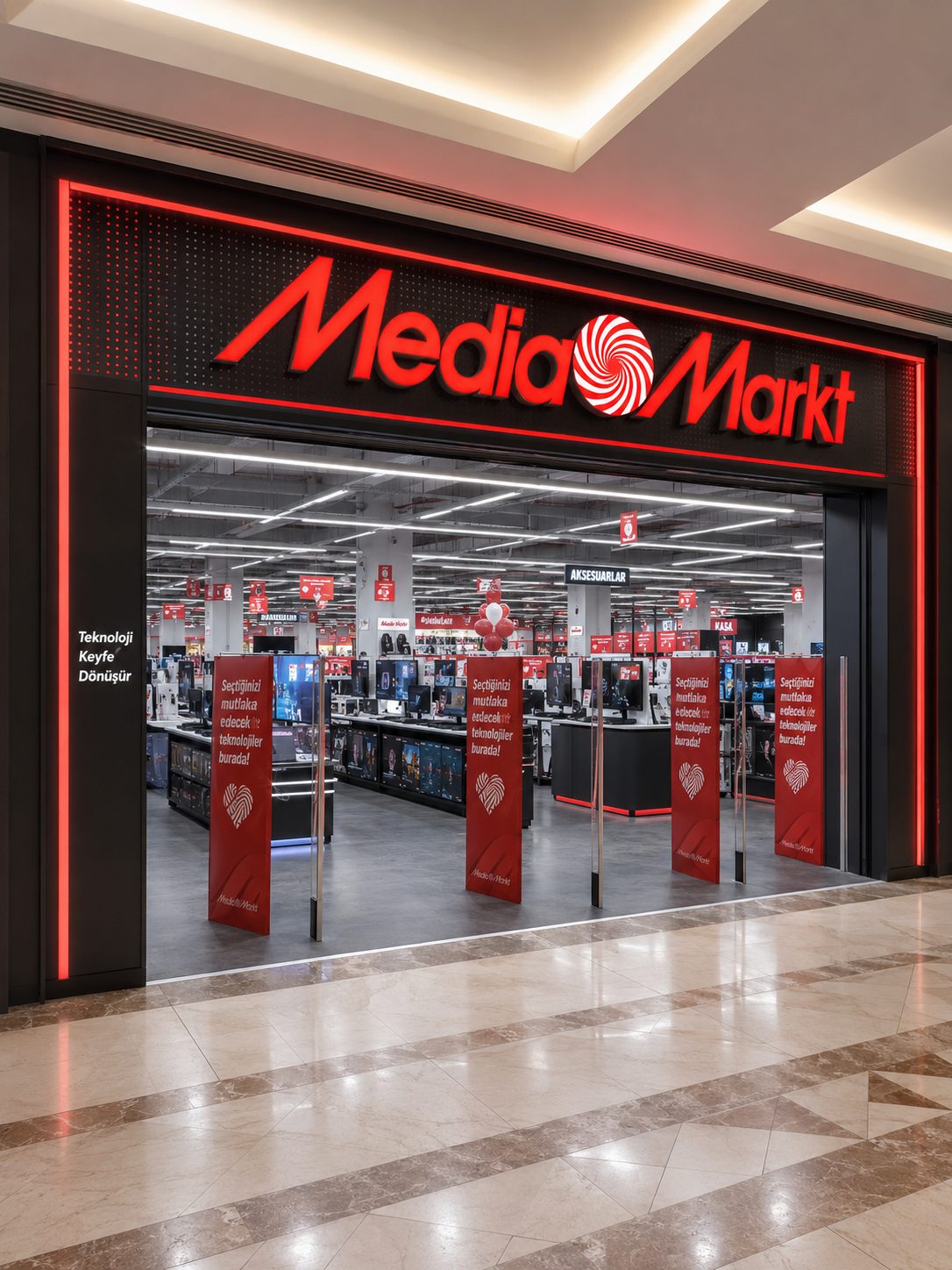 İşletmedeki MediaMarkt mağazasının girişi; aydınlatmalı tabela ve teşhir alanı.