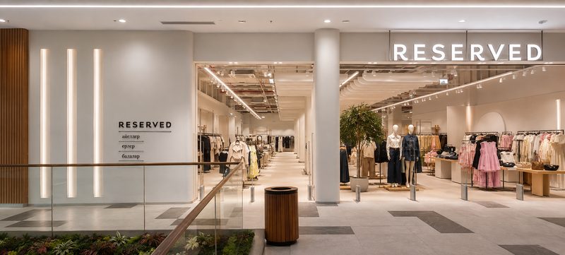 Alışveriş merkezi içinde Reserved mağazasının aydınlatmalı girişi ve satış alanı.